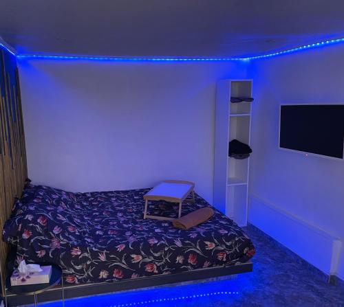 a bedroom with a bed with a blue light at Studio fonctionnel & central proche paris in Villeneuve-Saint-Georges