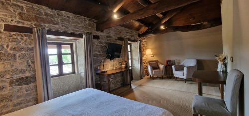 - une chambre avec un lit et un mur en pierre dans l'établissement Habitaciones La Cuevona de Guitiriz Lugo, à Guitiriz