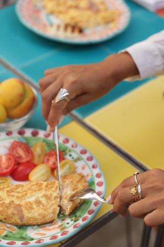 a person cutting a piece of food on a plate at Hotel Terme Oriente - Beach & SPA in Ischia