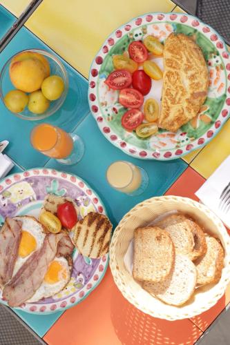 a table with two plates of breakfast food on it at Hotel Terme Oriente - Beach & SPA in Ischia