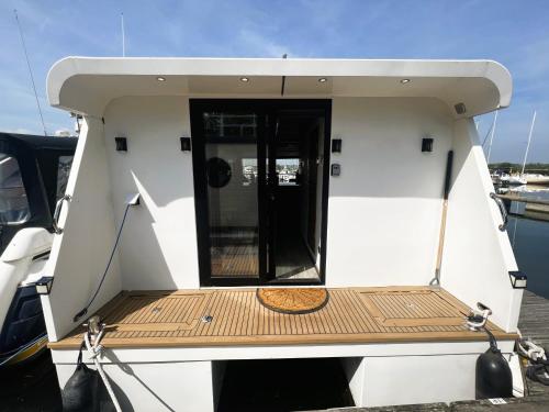 a small white boat with a wooden deck at Island Harbour Houseboat in Newport