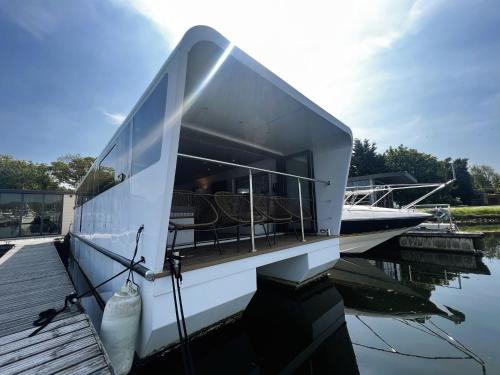 a large white boat is docked on the water at Island Harbour Houseboat in Newport