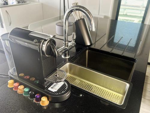 a kitchen sink with a coffee maker on a counter at Island Harbour Houseboat in Newport