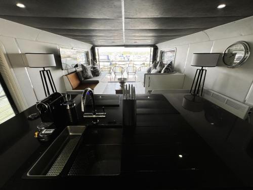 a kitchen with a sink and a living room at Island Harbour Houseboat in Newport