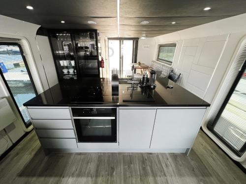 a kitchen with white cabinets and a black counter top at Island Harbour Houseboat in Newport