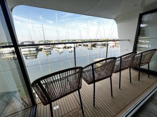 a balcony with chairs and a view of a marina at Island Harbour Houseboat in Newport