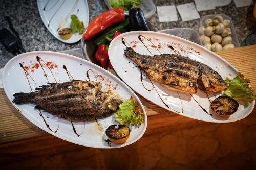 two plates of food with fish and vegetables on a table at Taverna & Rooms in Sutivan