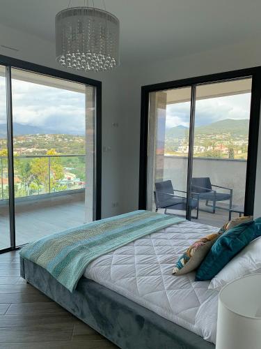 une chambre avec un grand lit et de grandes fenêtres dans l'établissement PORTICCIO Maison vue mer, à Porticcio