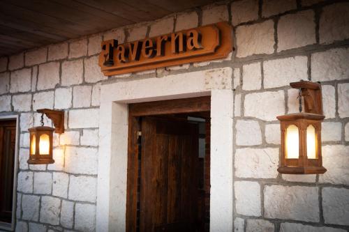 an entrance to a restaurant with a sign and lights at Taverna & Rooms in Sutivan
