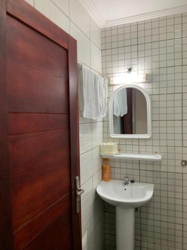 La salle de bains est pourvue d'un lavabo et d'une porte en bois. dans l'établissement Gokus Home, à Douala