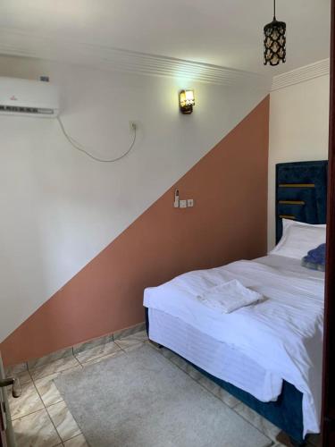 Gokus Home في دوالا: غرفة نوم مع سرير مع جدار لكنة بنية