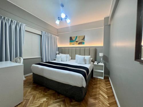 a hotel room with a large bed and a window at Hotel Facon Grande in Buenos Aires