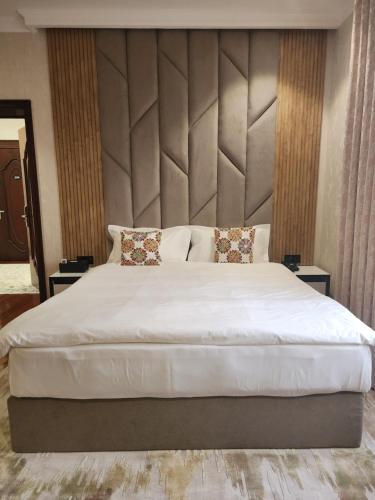 a bedroom with a large white bed with two pillows at HOTEL DEHLAVI o in Dushanbe