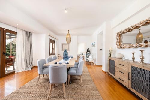 a dining room with a table and chairs and a mirror at Horizon Villa-Private Pool-7 Bedroom-Gym-Sea View in Psalidi