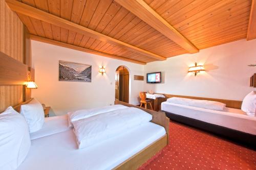 - une chambre avec deux lits et un plafond en bois dans l'établissement Chalet Tschallener, à Ried im Oberinntal
