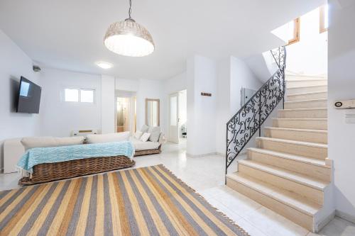 a white living room with a staircase and a couch at Horizon Villa-Private Pool-7 Bedroom-Gym-Sea View in Psalidi