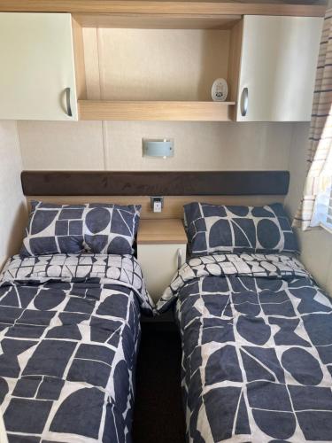 duas camas num pequeno quarto numa caravana em 21 Riverview, Allhallows em Rochester