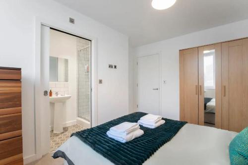 1 dormitorio con 1 cama con toallas en Central Gloucester Getaway Retreat W/Free Parking 