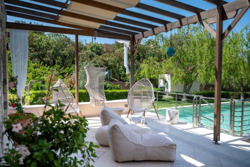 a patio with chairs and a swimming pool at Horizon Villa-Private Pool-7 Bedroom-Gym-Sea View in Psalidi