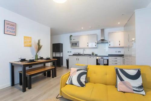 sala de estar con sofá amarillo y cocina en Central Gloucester Getaway Retreat W/Free Parking 
