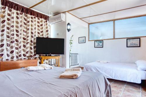 two beds in a room with a flat screen tv at Rincón de sol y relax in Torrevieja