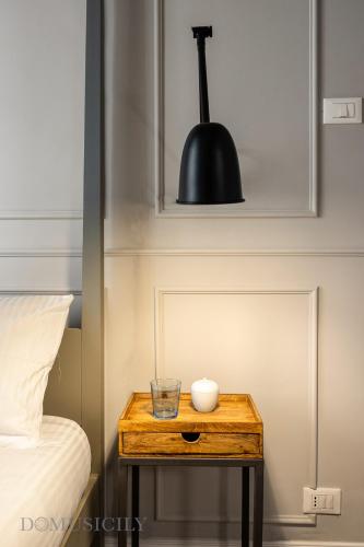 a small table with a bowl and a black lamp on it at Constance Luxury Apartment by DomuSicily in Palermo