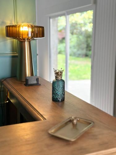 a table with a lamp and a candle on it at Le Clos Gabrielle in Châtellerault