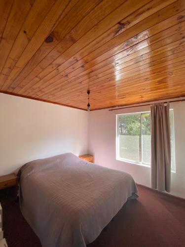 Un dormitorio con una cama grande y una ventana en Exquisito Loft en Punta de lobos - Tranquilo y cómodo, en Pichilemu