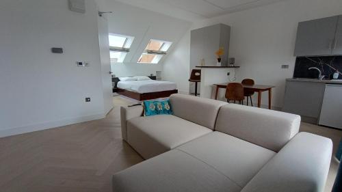 ein weißes Wohnzimmer mit einem Sofa und einem Bett in der Unterkunft Luxurious London Studios in Harrow