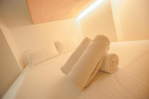 a white bed with two pillows and a roll on it at Double H Boutique Hotel in Kuala Terengganu