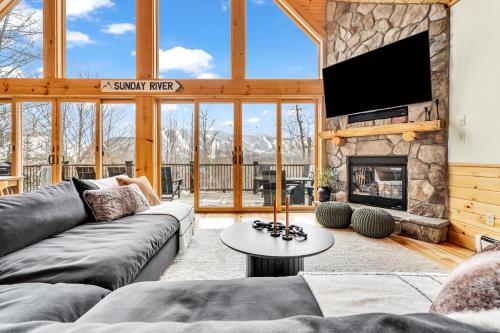 a living room with a couch and a fireplace at Chalet*Mountain Views*3-mins Sunday River*Hot Tub in Newry