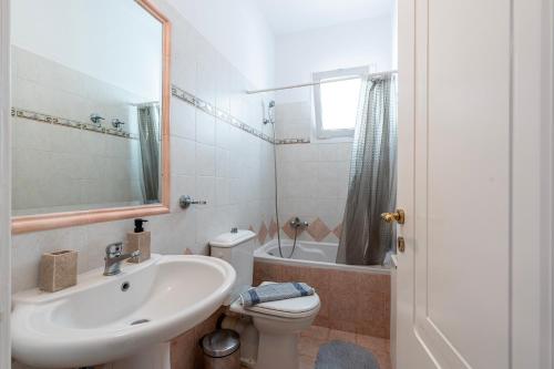 a white bathroom with a sink and a toilet at Horizon Villa-Private Pool-7 Bedroom-Gym-Sea View in Psalidi