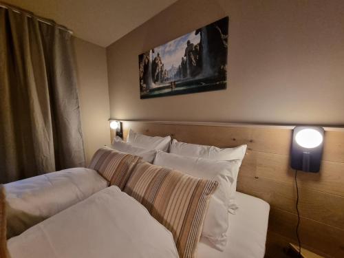 1 dormitorio con 2 camas y almohadas blancas en Villa The high end of Lofoten, en Moskenes