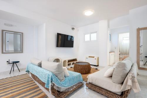 a living room with two chairs and a flat screen tv at Horizon Villa-Private Pool-7 Bedroom-Gym-Sea View in Psalidi