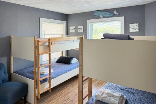a bedroom with two bunk beds and a chair at Here Comes the Sun in Corolla
