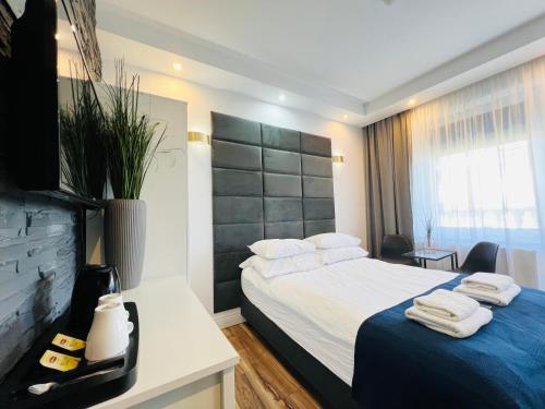 une chambre d'hôtel avec un lit et des serviettes. dans l'établissement Apartamenty DELUXE-Willa DAHARA-Grupa PlażoweLove, à Krynica Morska