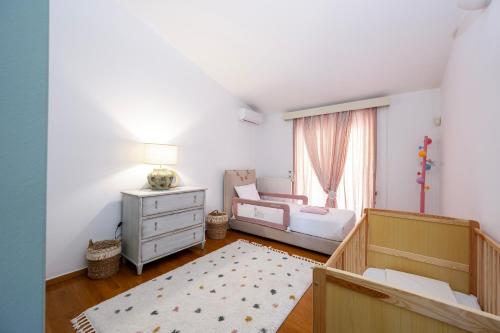 a bedroom with a bed and a dresser and a window at Horizon Villa-Private Pool-7 Bedroom-Gym-Sea View in Psalidi