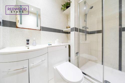 a bathroom with a shower and a toilet and a sink at QUALITY SERVICED APARTMENTS IN CAMBERLEY TOWN CENTRE, FREE WiFi, PERFECT FOR BUSINESS STAYS, FAMILIES, RELOCATIONS, EXTENDED STAYS, AND EMERGENCY ACCOMMODATION by REDWOOD STAYS in Camberley