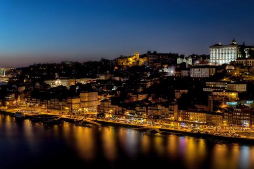 a view of a city at night with a river at Douro View Apartment in Vila Nova de Gaia