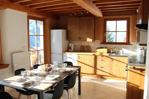 una cocina con una mesa con platos y vasos. en Chalet Les Ecrins, en Villard-Reculas