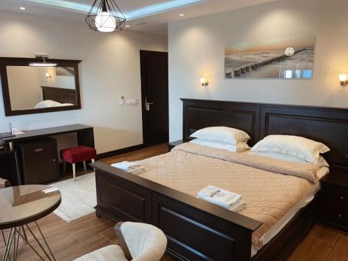 a bedroom with a large bed and a mirror at Padam Hotel & SPA in Ulcinj