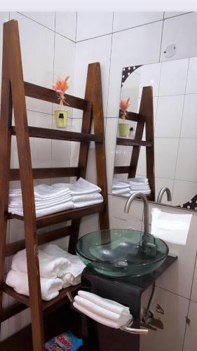 een badkamer met een wastafel, een spiegel en handdoeken bij treasury in Bagamoyo