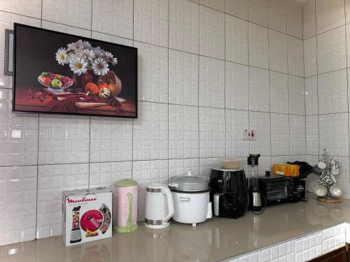 um balcão de cozinha com uma fotografia de flores na parede em treasury em Bagamoyo