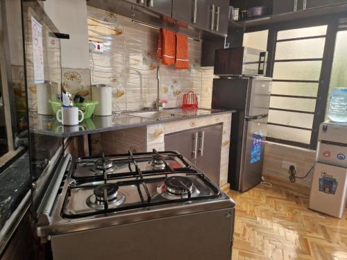 a kitchen with a stove top oven in a kitchen at Studio Alken - Moi South Lake Road in Naivasha
