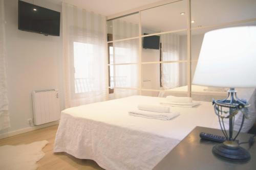 ein Zimmer mit einem Bett mit einem Spiegel und einer Lampe in der Unterkunft Apartamento en Ribeira in Ribeira