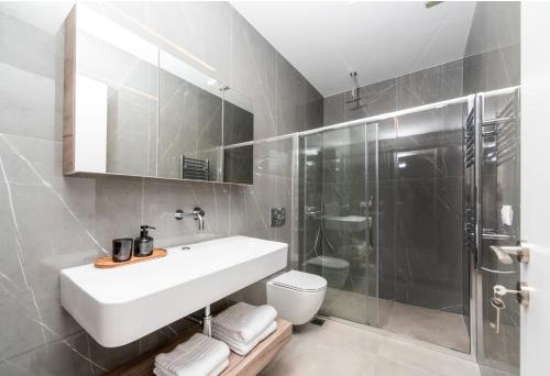 Un baño con lavabo, ducha e inodoro. en Serene villas halkidiki - Superior, en Nea Iraklia