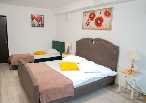 een slaapkamer met 2 bedden en een tafel met lampen bij Casa Alis in Oradea