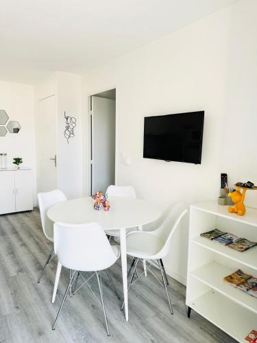 une salle à manger blanche avec une table blanche et des chaises blanches dans l'établissement Appartement T2 4 personnes RDC 50m plage et corniche, à Saint-Hilaire-de-Riez