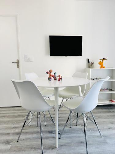 une salle à manger blanche avec une table blanche et des chaises blanches dans l'établissement Appartement T2 4 personnes RDC 50m plage et corniche, à Saint-Hilaire-de-Riez