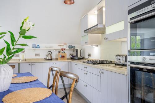 a kitchen with white cabinets and a table with chairs at York Cottage in Whitby